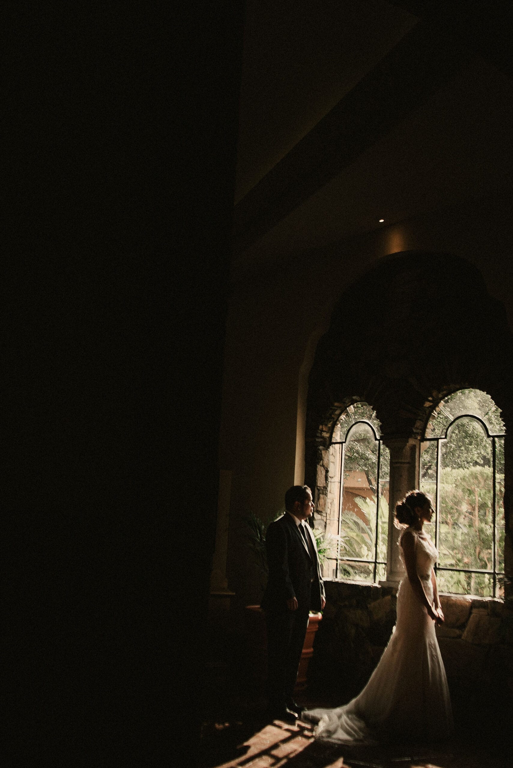 Pareja de novios junto a ventana durante sesión de boda en Monterrey fotografía documental
