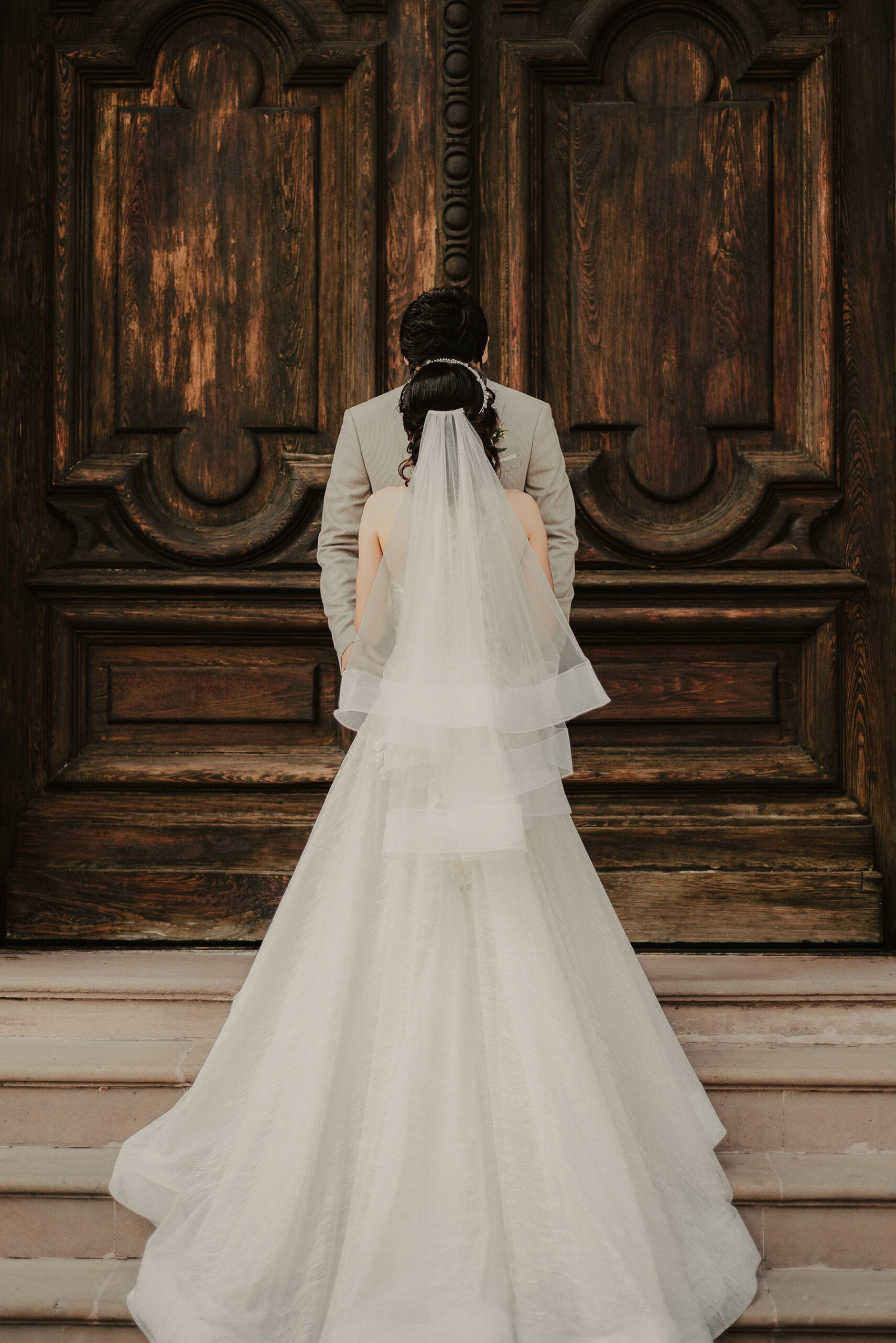 Novios frente a puerta de iglesia durante boda en Monterrey fotografía artística documental